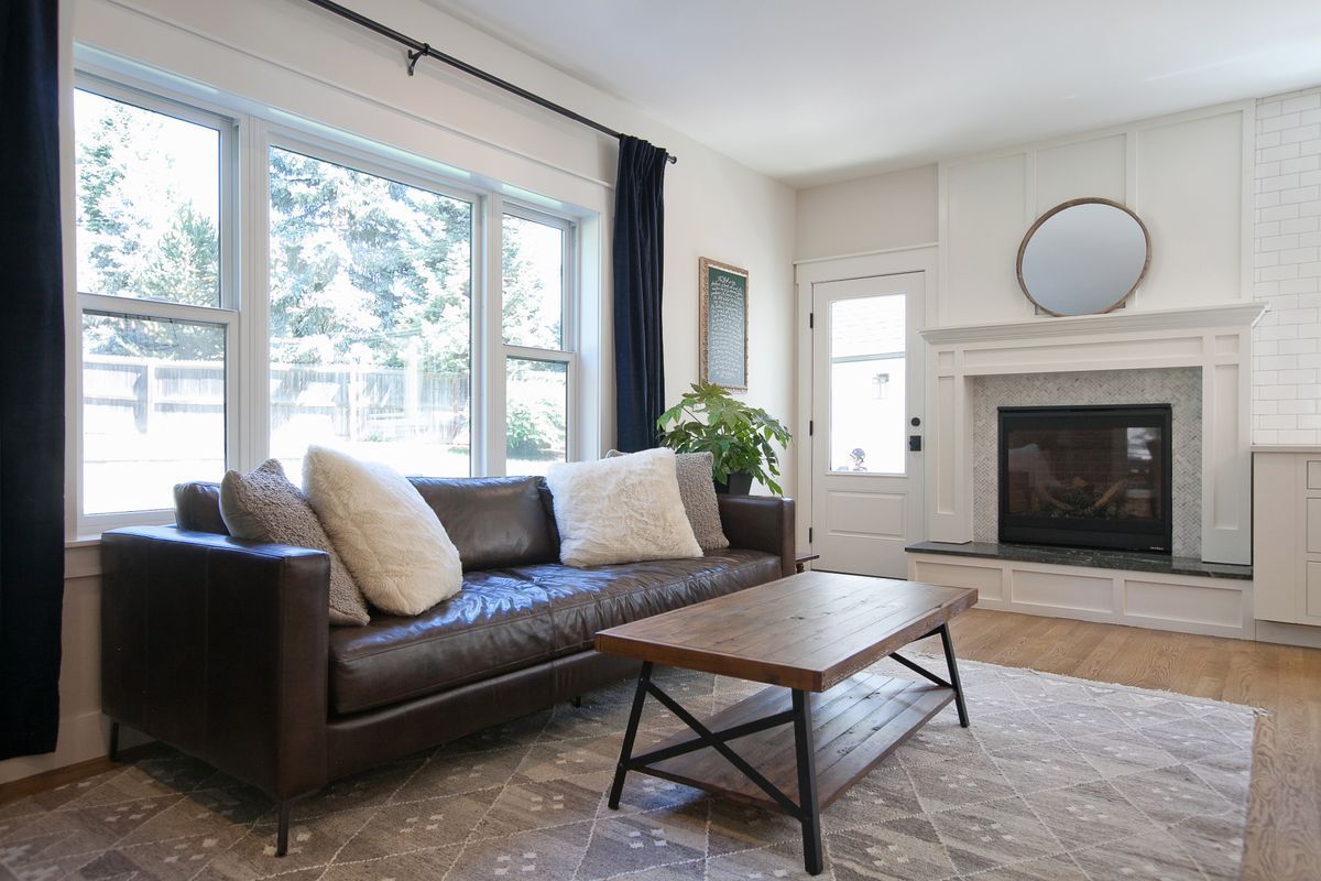 A living room with a couch, coffee table, and fireplace.