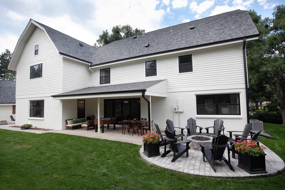 A large white house with a fire pit in the backyard.