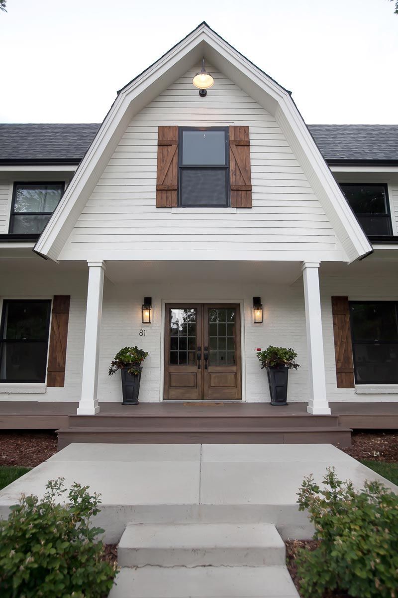 A large white house with a driveway leading to it.