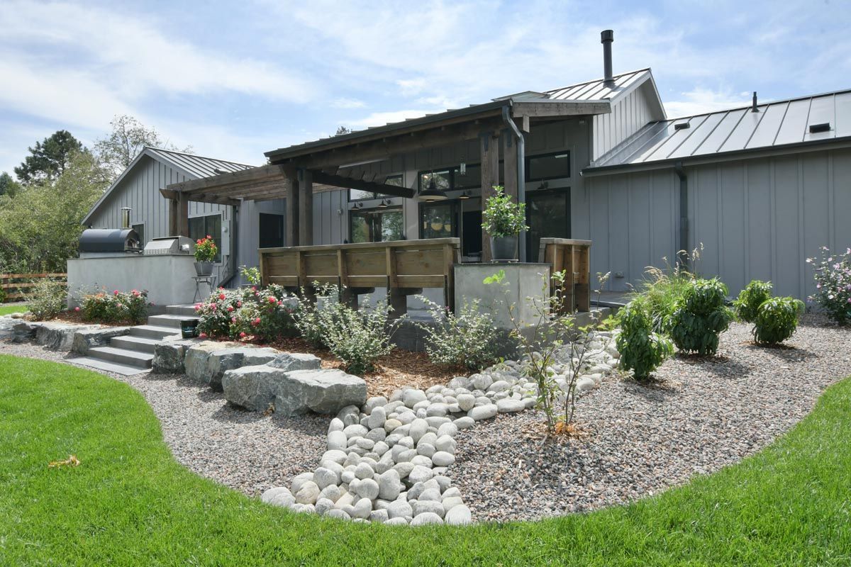 A large house with a covered porch and a large lawn in front of it.
