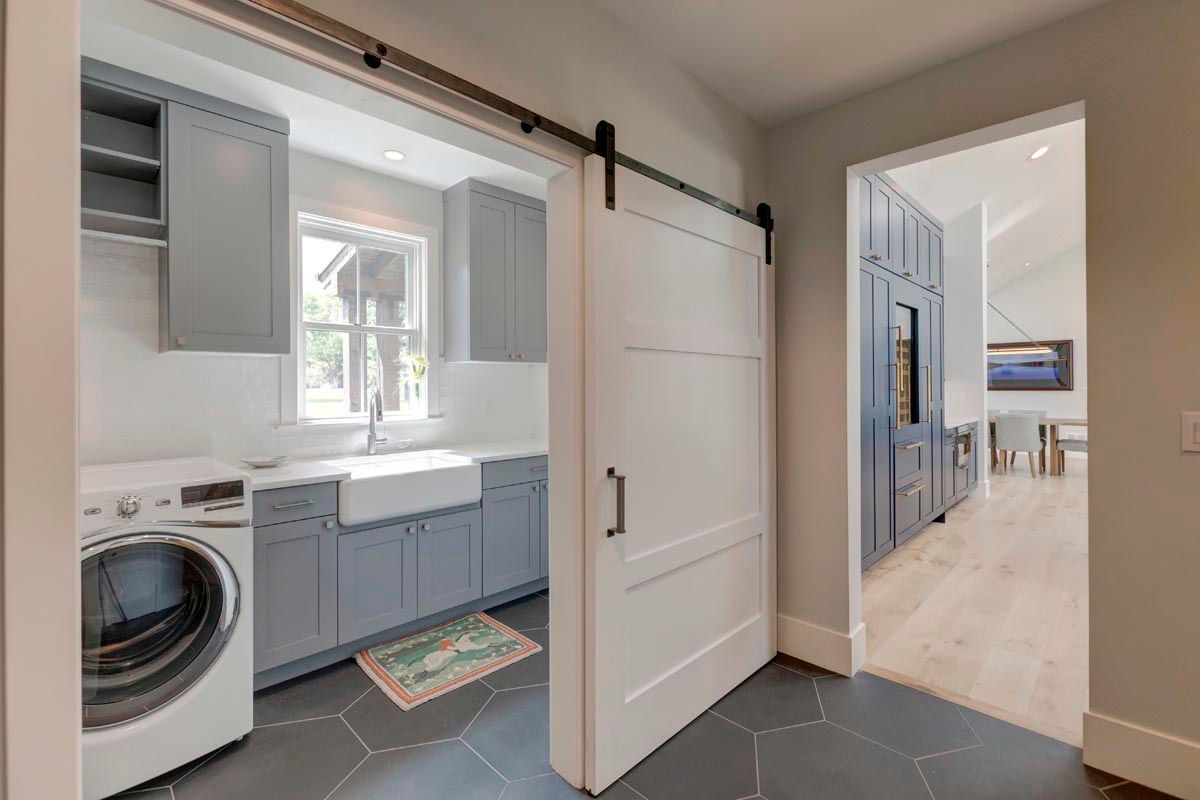 A laundry room with a washer and dryer and a sliding barn door.