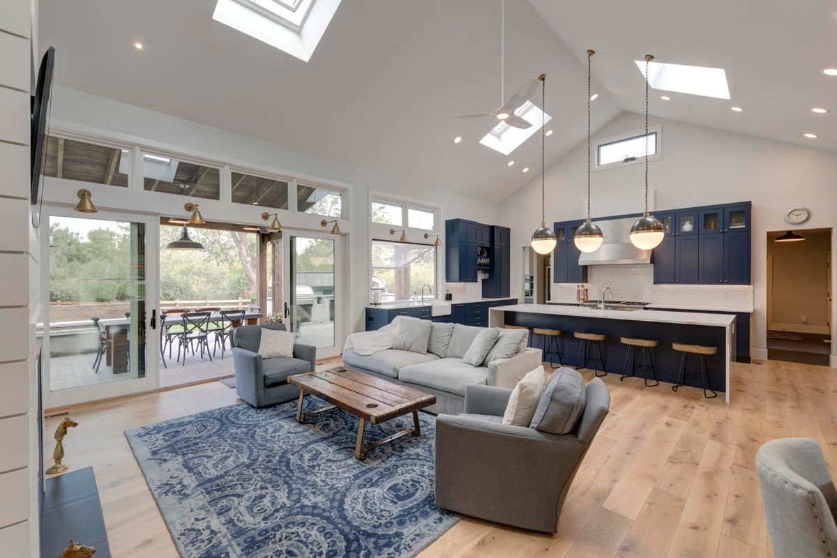 A living room with a couch, chairs, a coffee table, and a rug.