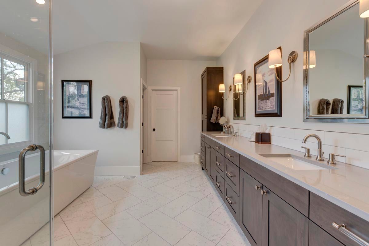 A bathroom with a bathtub, sink, mirror, and walk in shower.