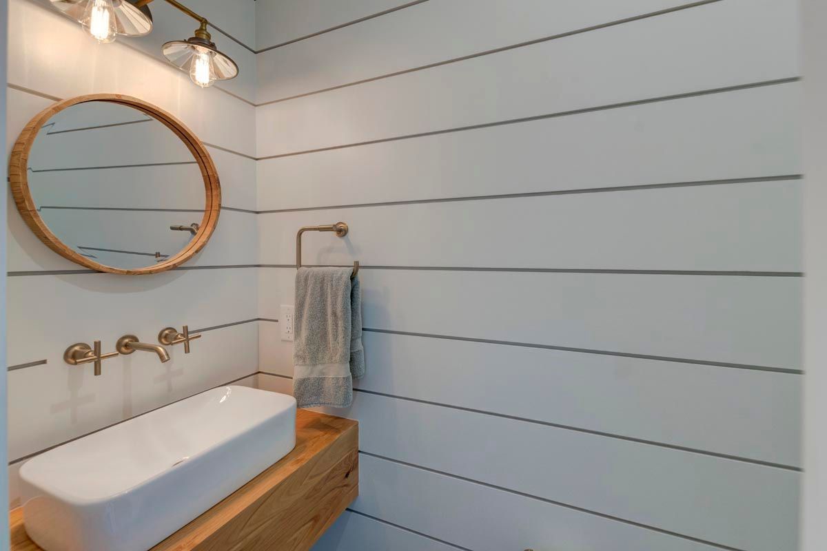 A bathroom with a sink and a mirror on the wall.