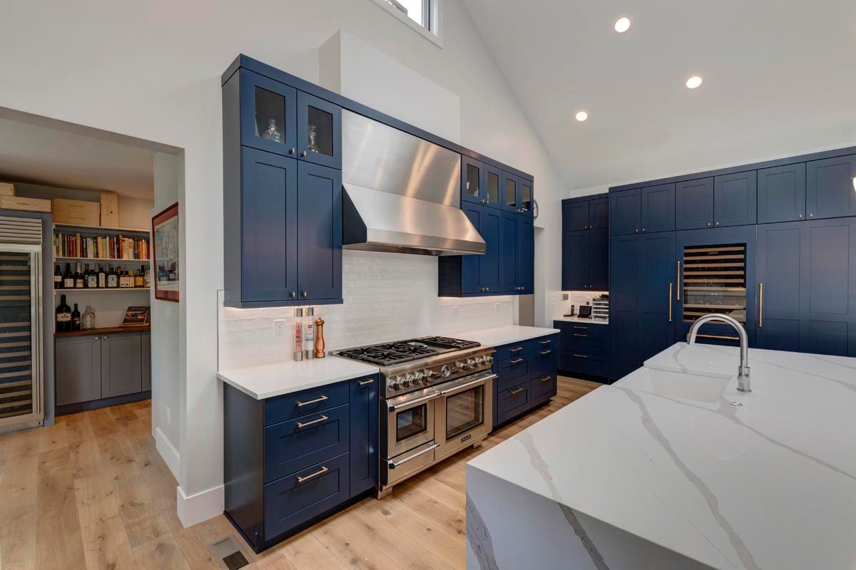 A kitchen with blue cabinets and stainless steel appliances.