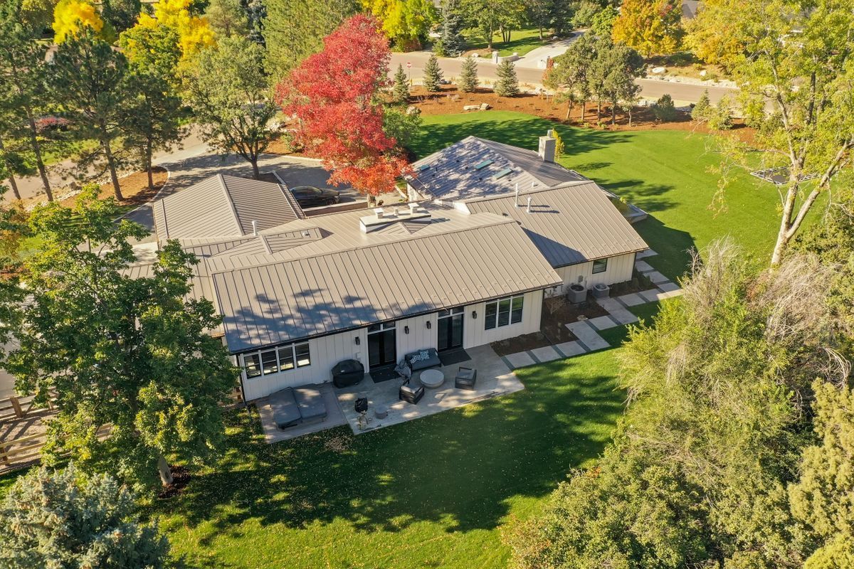 An aerial view of a house surrounded by trees and grass.