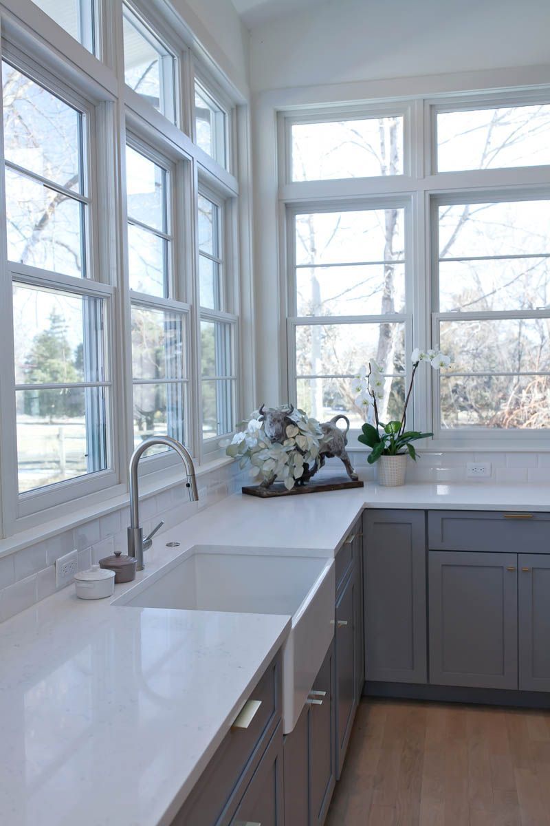 A kitchen with two sinks and a lot of windows.