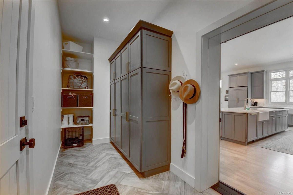 A hallway in a house with a hat hanging on the wall.