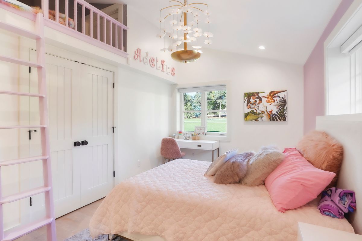A bedroom with a bed, desk, and ladder.