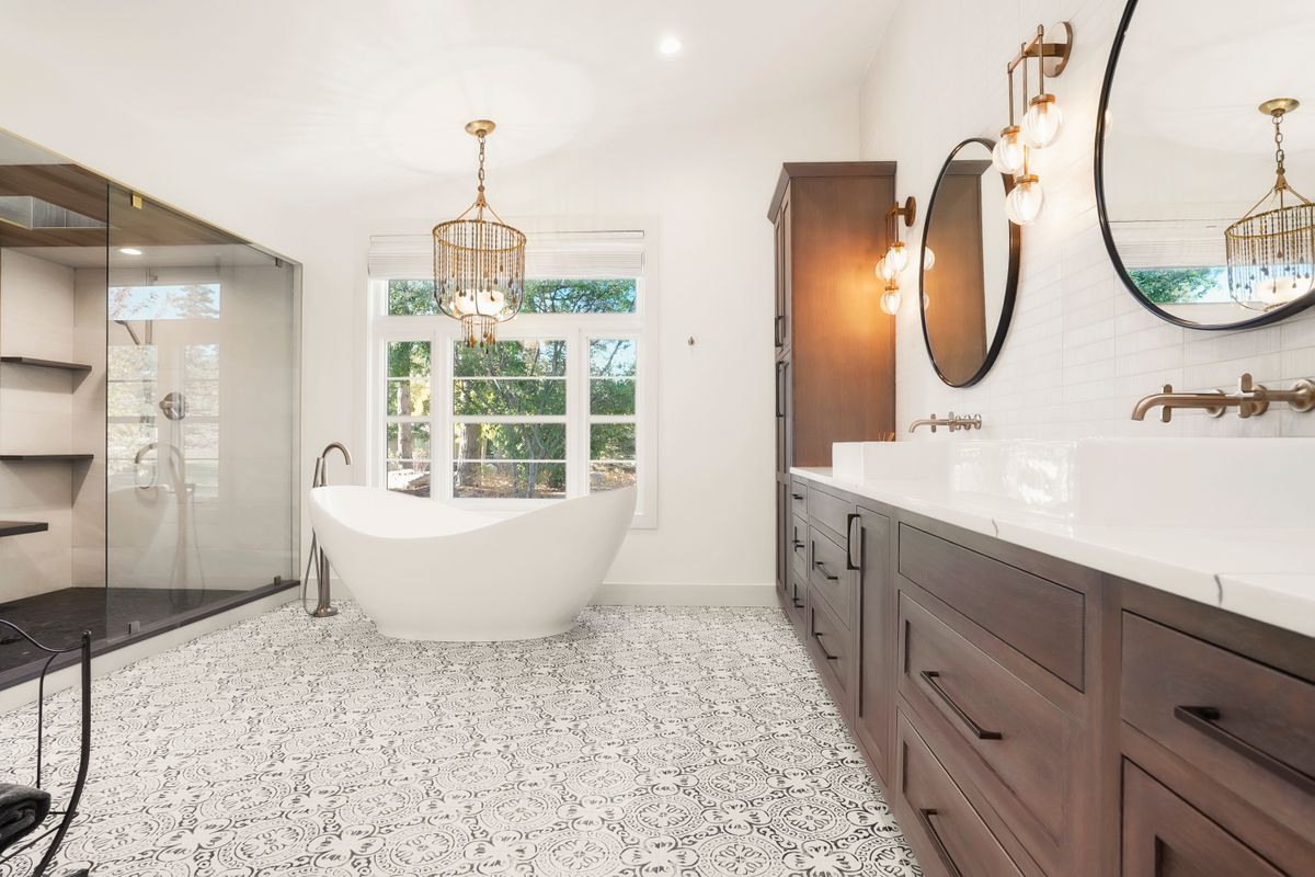 A bathroom with a bathtub, sinks, mirrors, and a walk in shower.