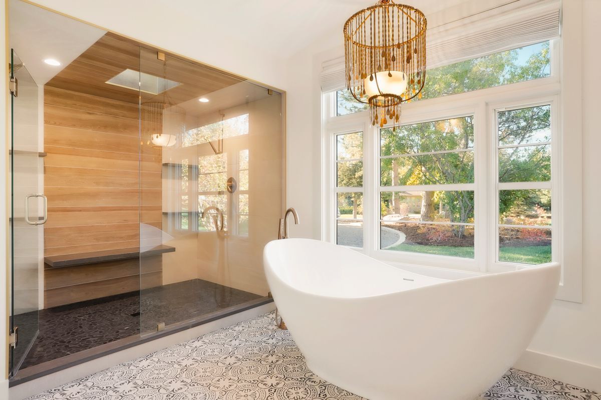 A bathroom with a tub, shower, and window.