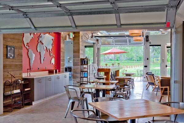 A restaurant with tables and chairs and a map of the world on the wall.