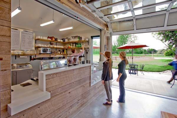 Two women are standing in front of a counter in a restaurant.