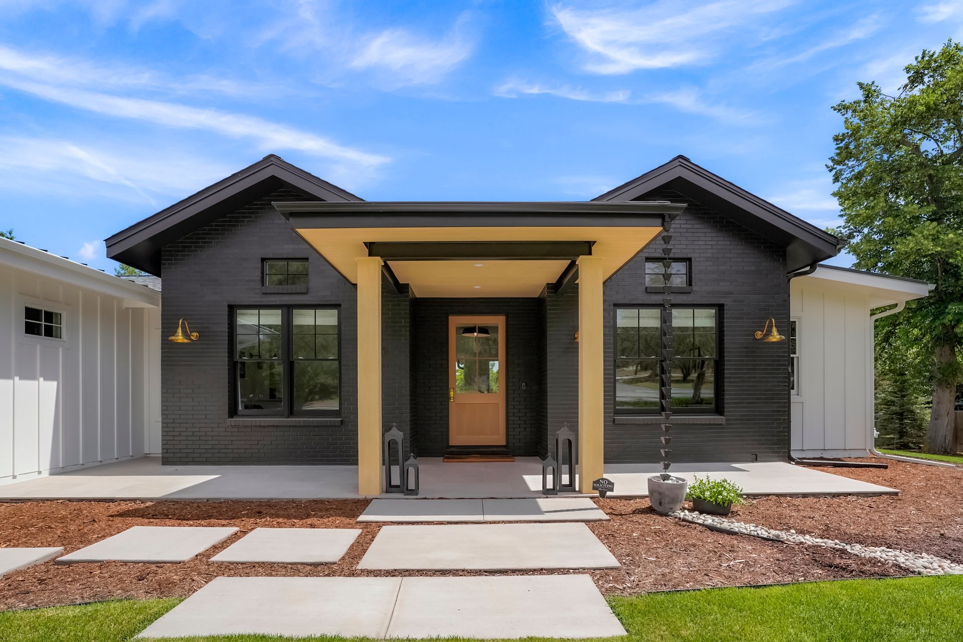 The front of a black and white house with a porch