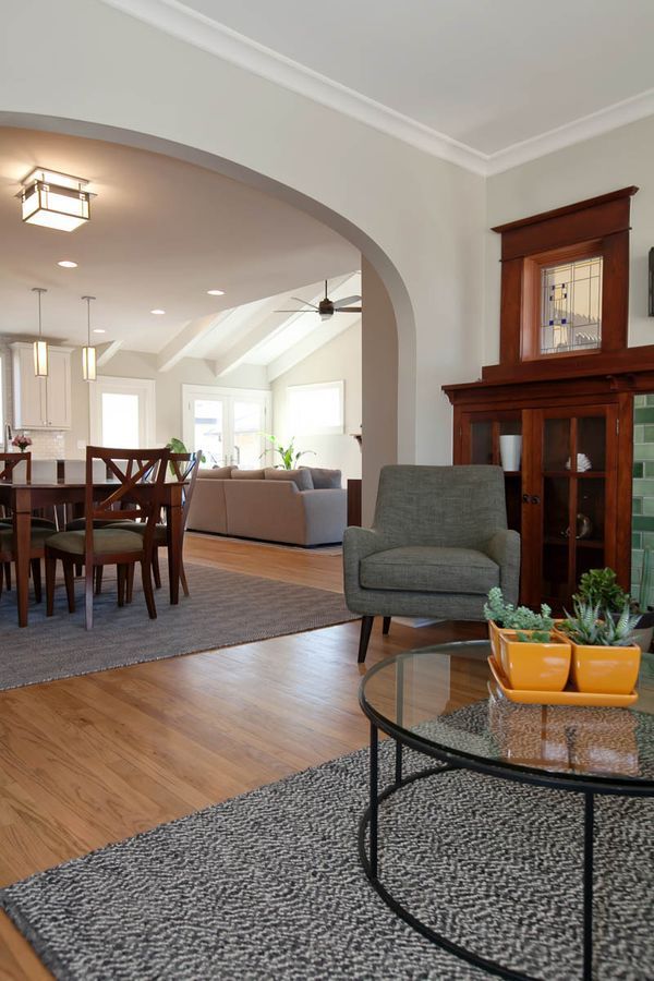 A living room with a glass coffee table and a chair.