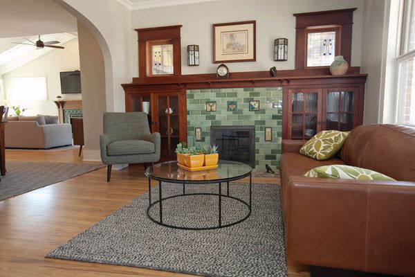 A living room with a couch a chair and a fireplace.