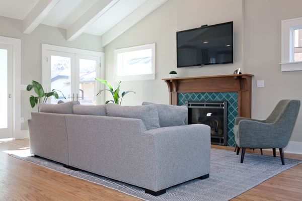A living room with a couch, chair, television, and fireplace.