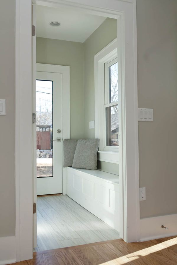 A doorway leading to a room with a bench and a window.