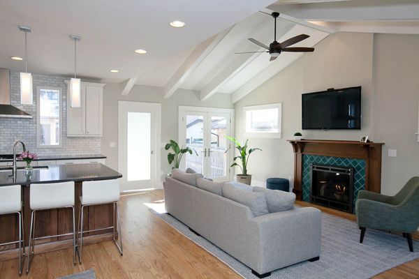 A living room with a fireplace and a ceiling fan.