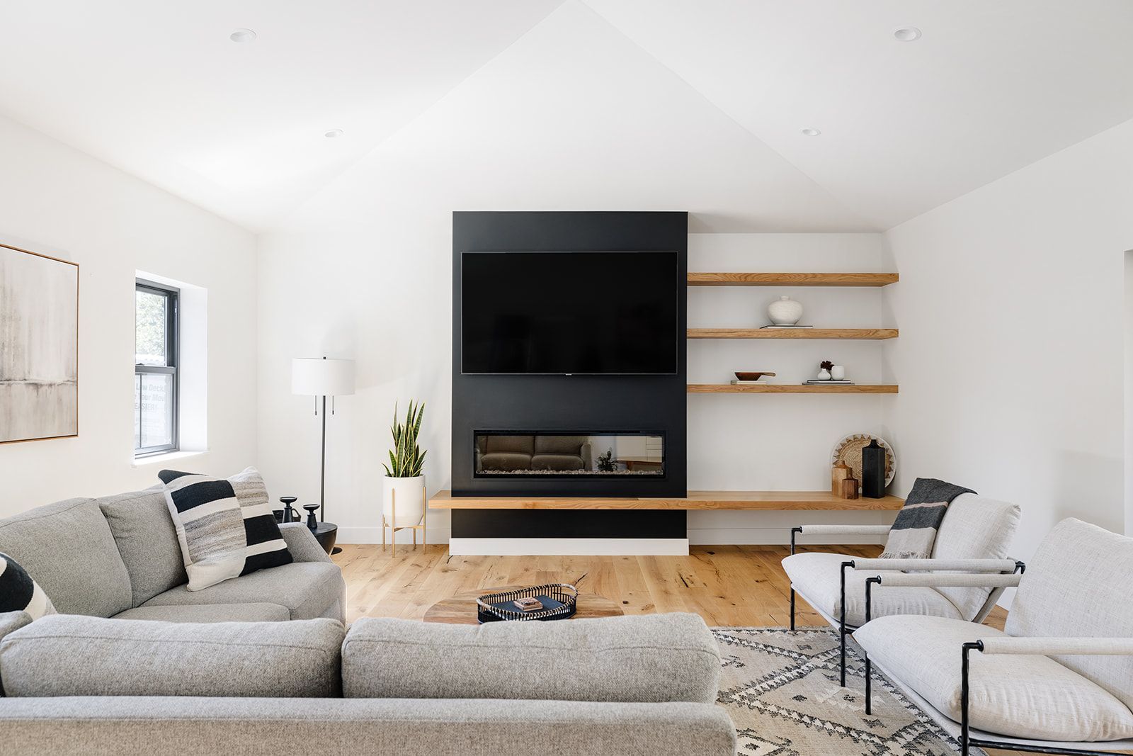 A living room with a couch, chairs, and a flat screen tv.