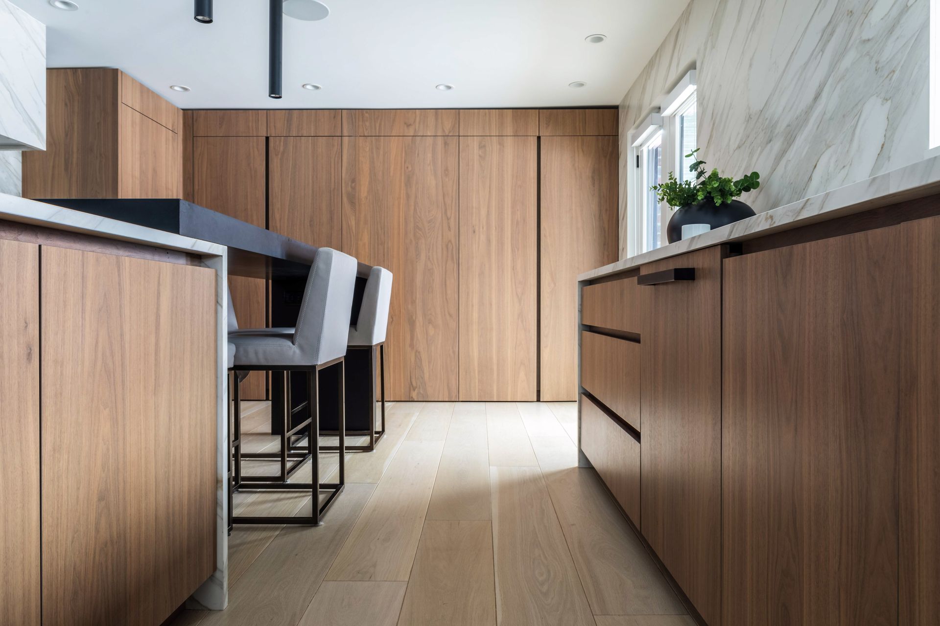 A kitchen with wooden cabinets and marble counter tops.