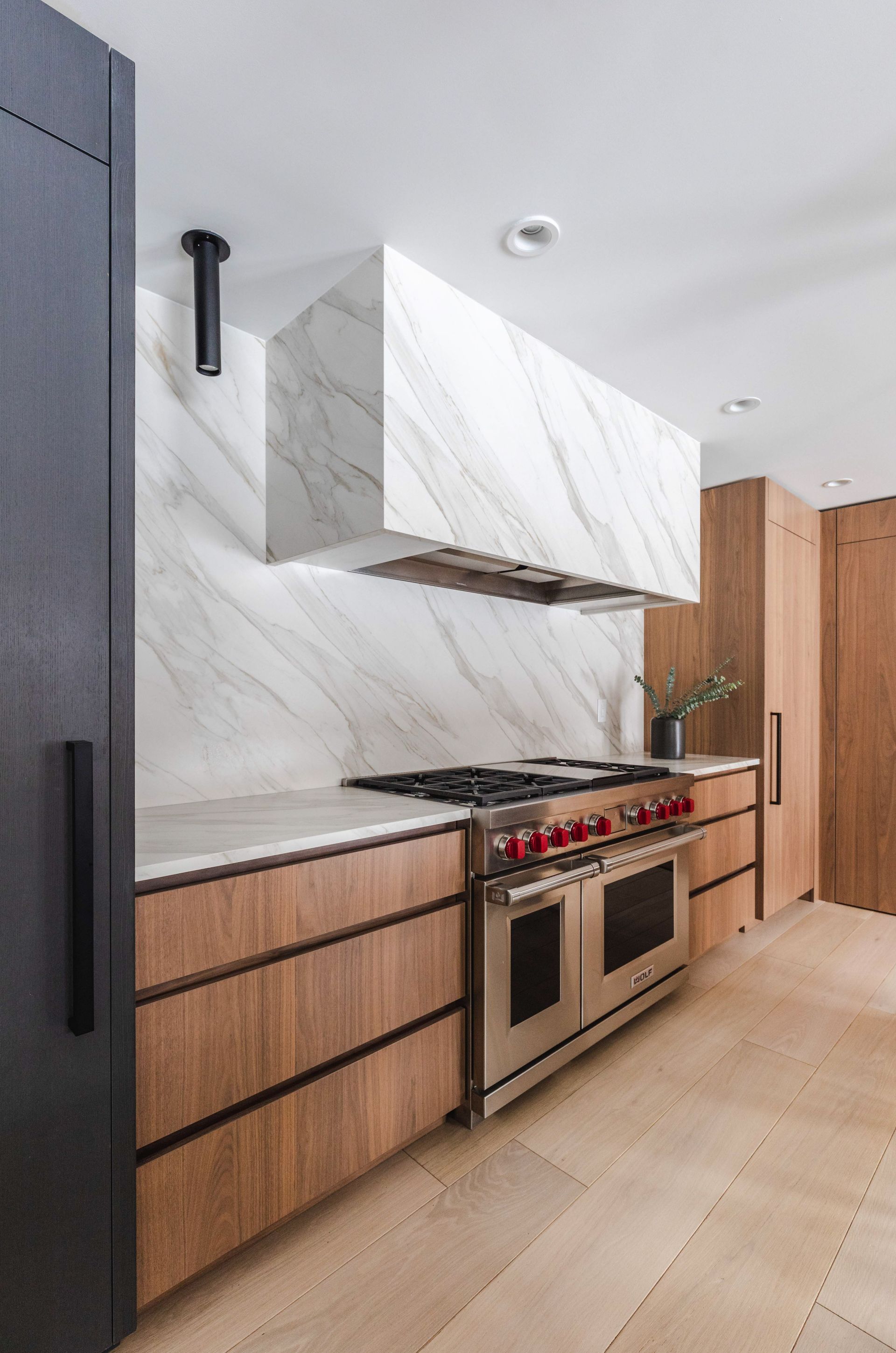 A kitchen with wooden cabinets , a stove , and a refrigerator.