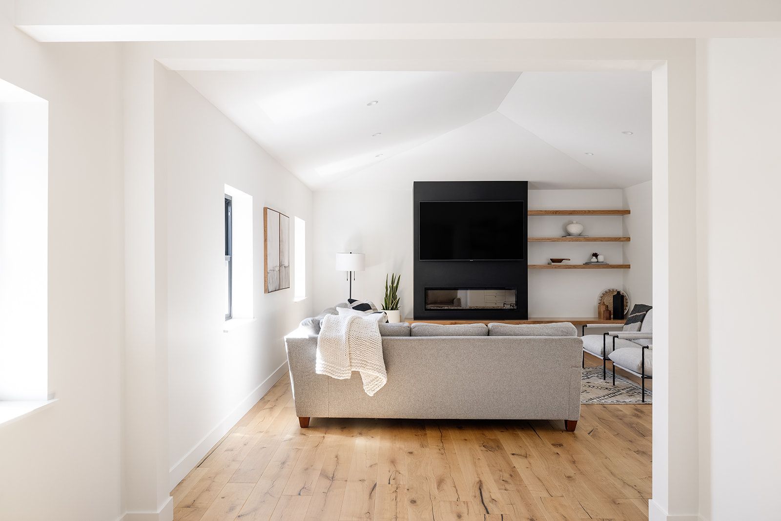 A living room with a couch , fireplace and television.
