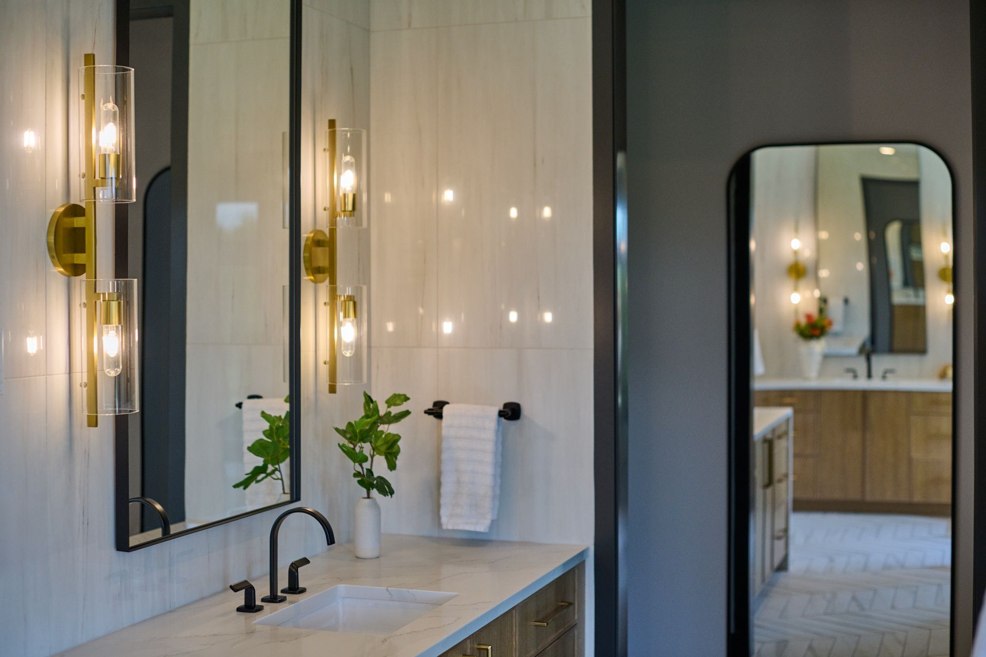 A bathroom with a sink, mirror, and light fixtures.