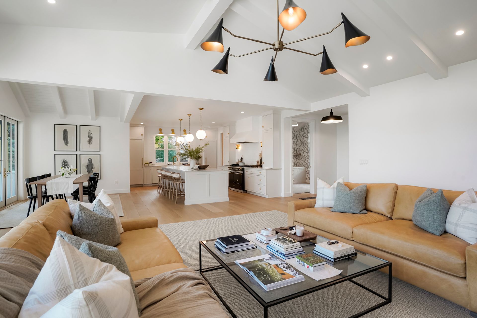 A living room with a couch, coffee table, and chandelier.