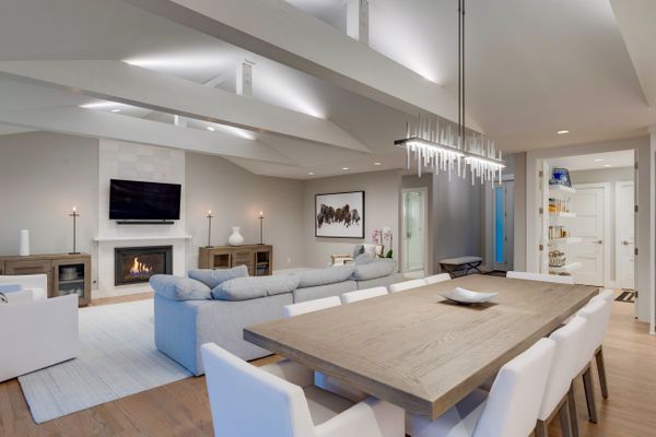 A bedroom with a large bed, chairs, and windows