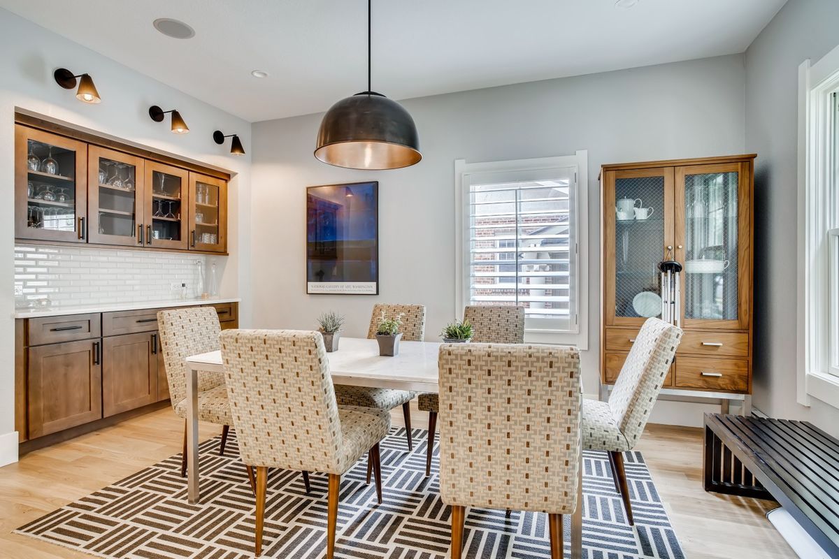 A dining room with a table and chairs and a rug.