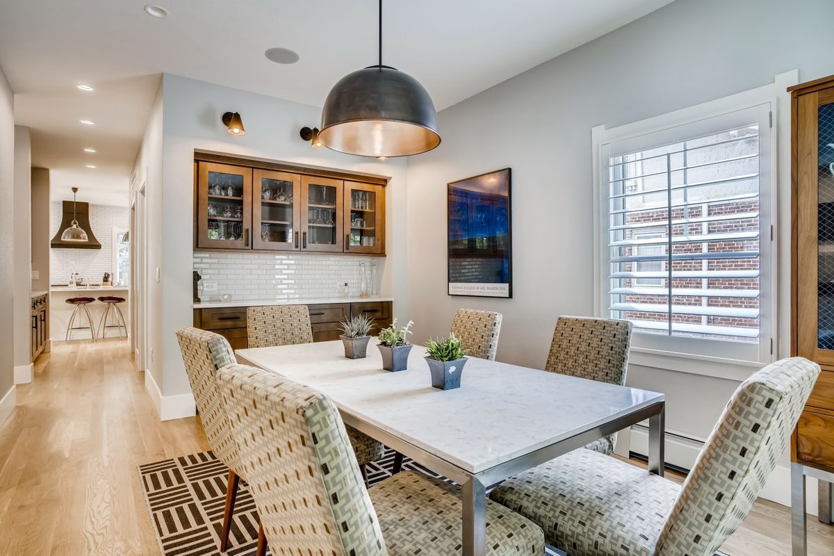 A dining room with a table and chairs and a window.