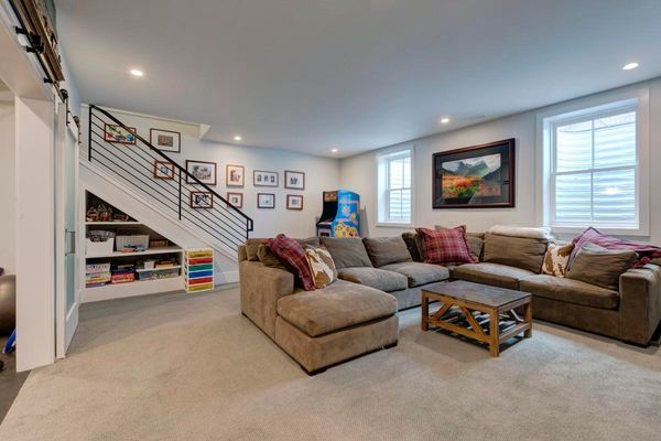 A living room with a couch, coffee table, and stairs.