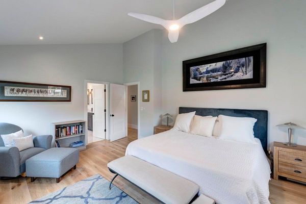 A bedroom with a large bed and a ceiling fan.