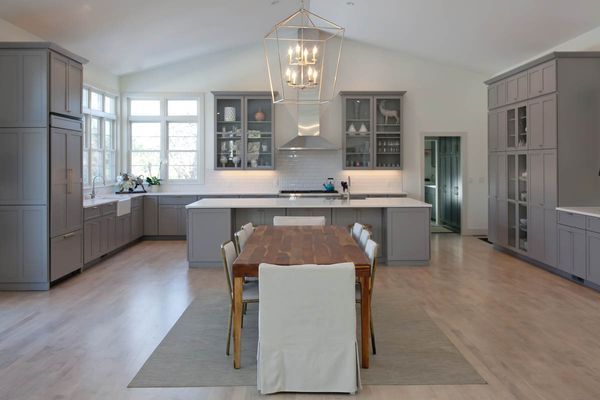 A large kitchen with a table and chairs in it.