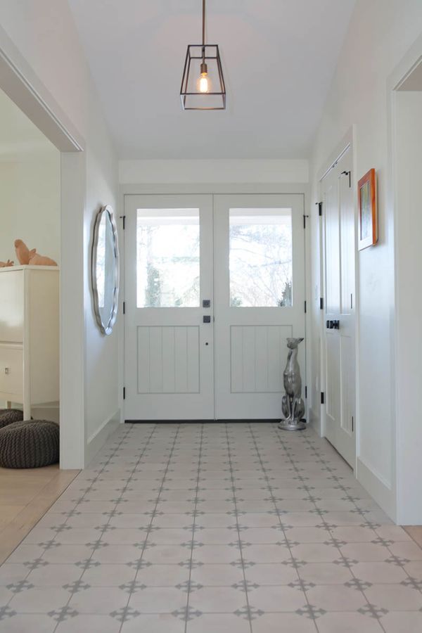 A hallway with a vacuum cleaner on the floor and a mirror on the wall.