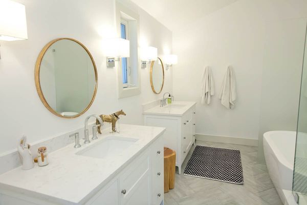 A bathroom with two sinks, two mirrors, and a bathtub.