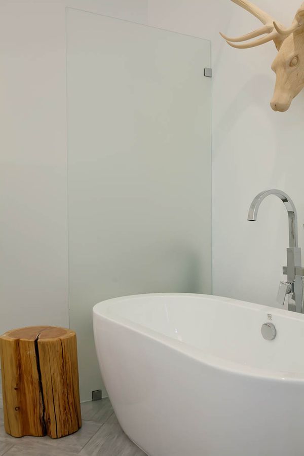 A bathroom with a bathtub and a wooden stool.
