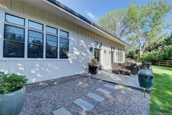 A house with a lot of windows and a patio in front of it.