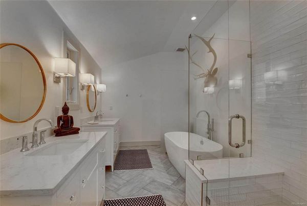 A bathroom with two sinks, a bathtub, and a walk in shower.