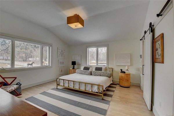 A bedroom with a king size bed and a striped rug.
