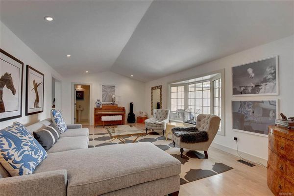 A living room with a couch and chairs in it.