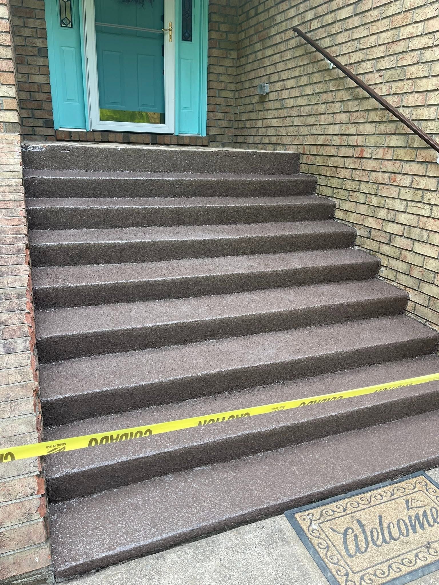Stone steps leading to a turquoise door, with yellow caution tape across the bottom step.