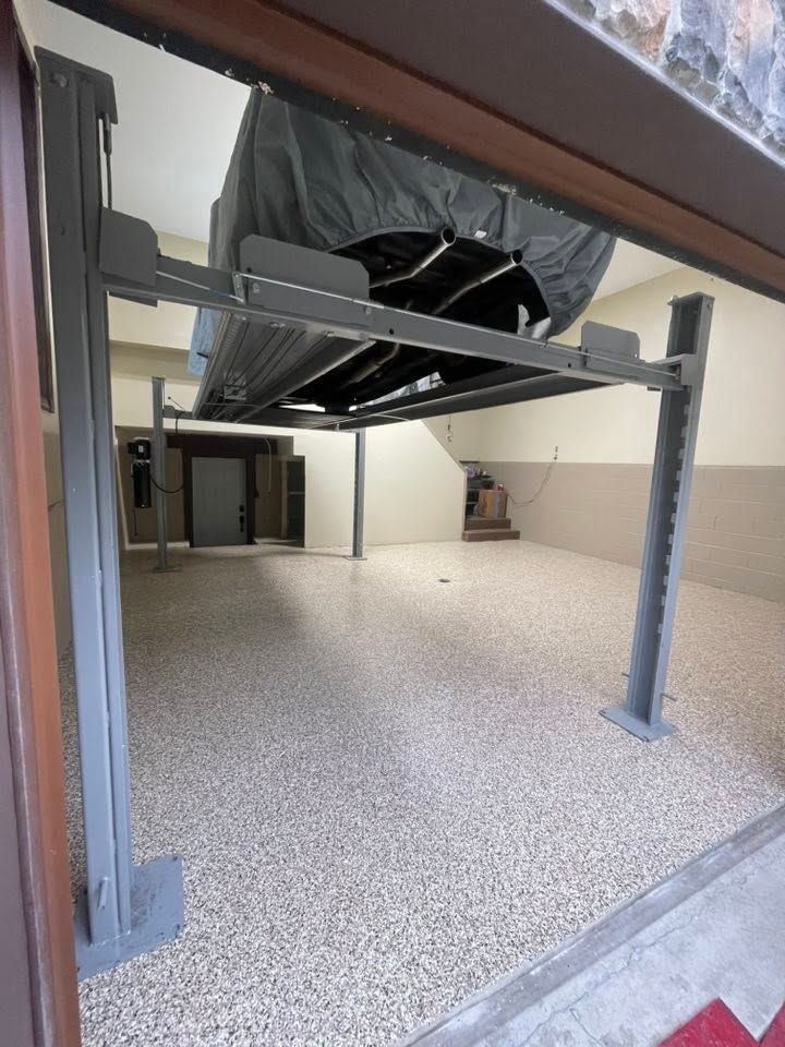 Empty room with carpet, exposed steel beams, and covered equipment overhead.