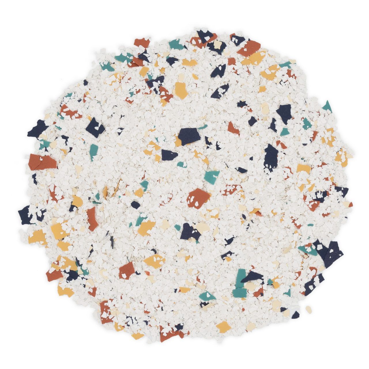 White granulated surface with scattered blue, orange, and teal flakes in a round pile