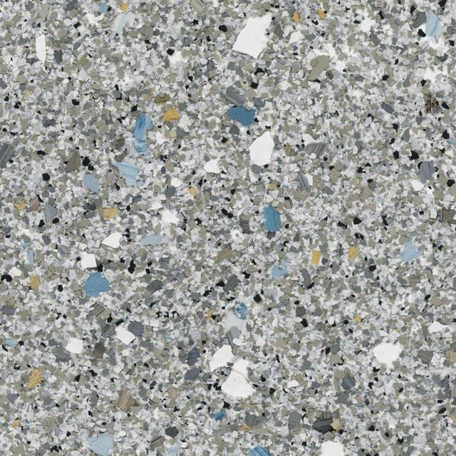 Close-up of gray speckled stone or concrete surface with scattered white and blue flecks