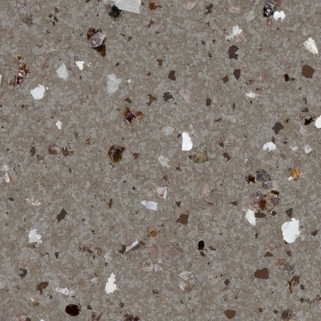 Close-up of a gray speckled stone surface with scattered white and brown flecks.