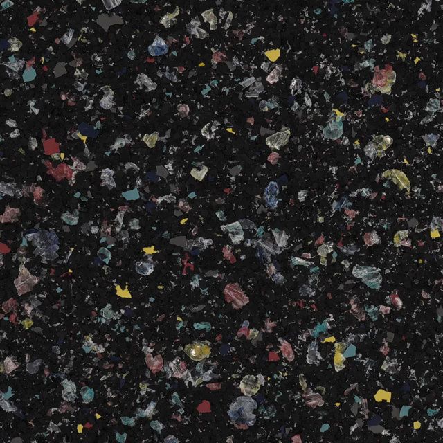 Close-up of black speckled surface with colorful flecks of red, yellow, blue, and white
