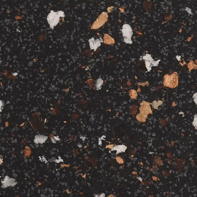 Close-up of dark speckled stone with scattered white and tan flecks