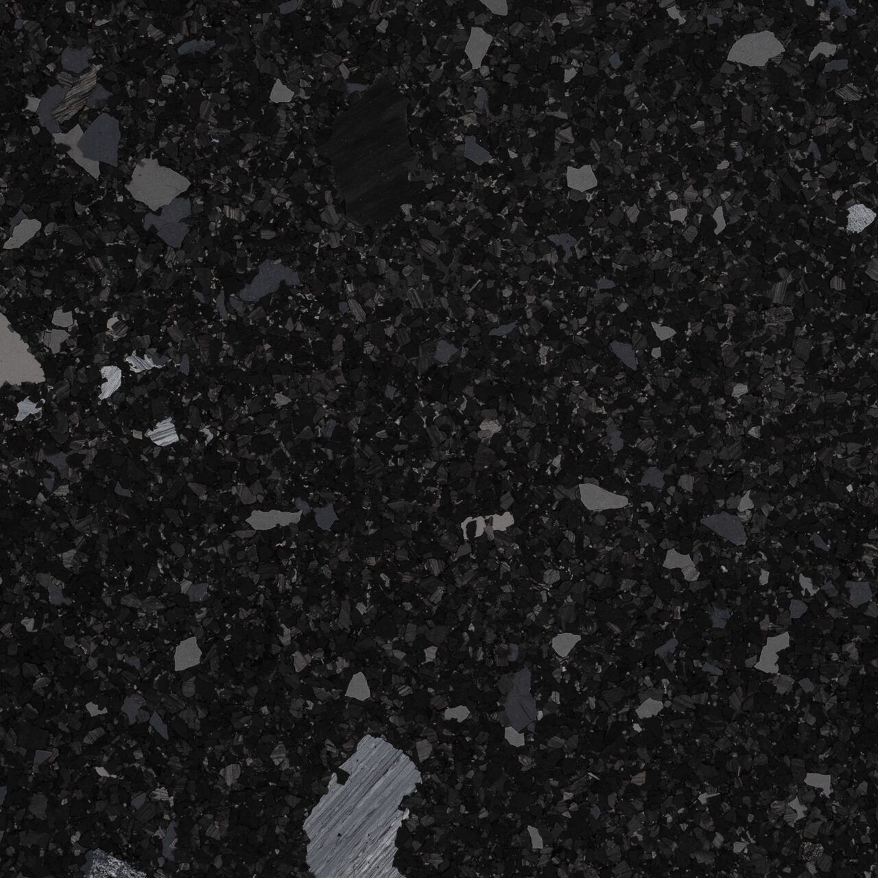 Dark speckled black stone or granite surface with scattered gray flecks and a larger light gray patch near the bottom.